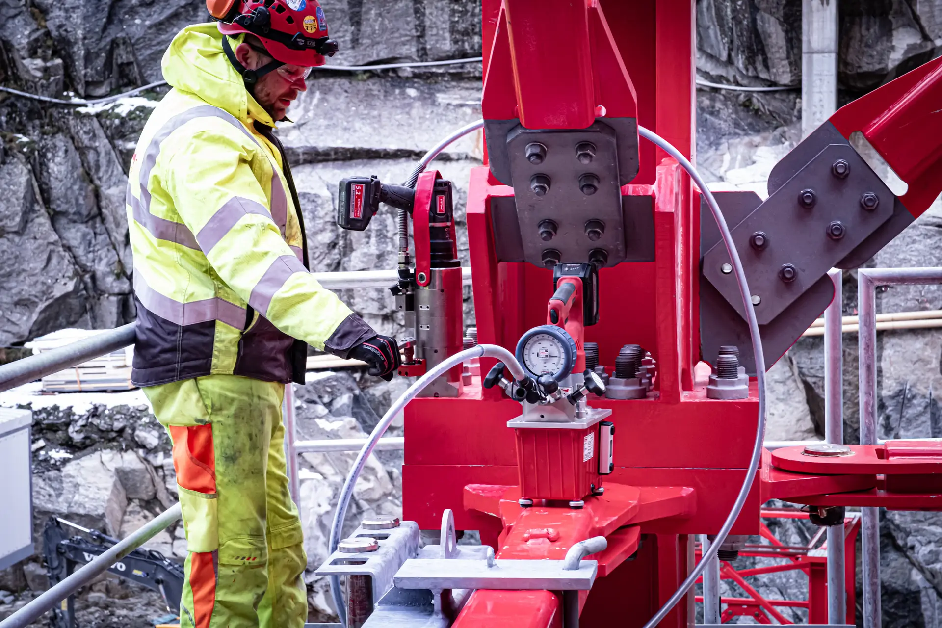 Ein Monteur setzt einen ITH Akku-Drehmomentschrauber mit externer Hydraulikpumpe zur Montage einer Trägerverschraubung an einer Stahlstruktur im Außenbereich ein.